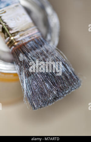 a paint brush lies on a paint pot Stock Photo