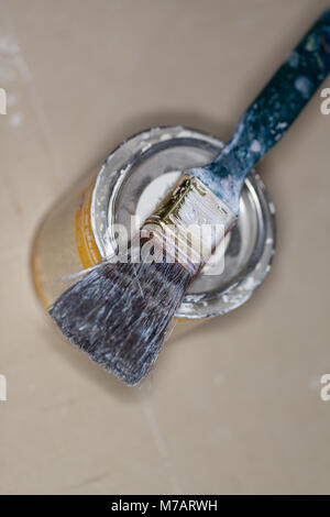 a paint brush lies on a paint pot Stock Photo
