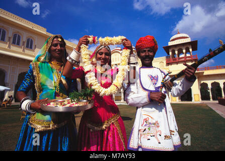 Portrait of a mid adult man with two young women greeting, Jaipur, Rajasthan, India Stock Photo
