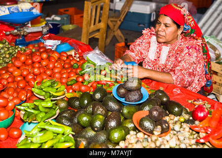 Mid adult woman selling vegetables, Tlacolula De Matamoros, Oaxaca State, Mexico Stock Photo