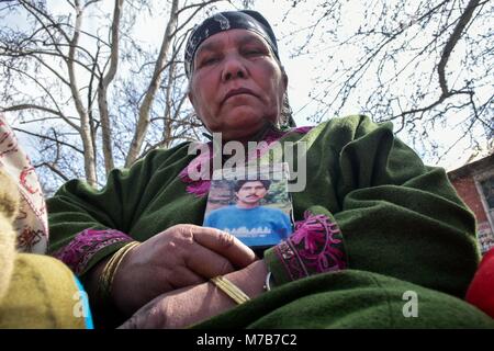 Srinagar, India. 10th Mar, 2018. A relative holds a photograph of a disappeared person during a protest organized by the Association of Parents of Disappeared Persons (APDP) in Srinagar, Indian administered Kashmir. Members of the APDP gathered for their monthly demonstration and demanded the creation of an independent commission to investigate disappearances in the region. Credit: Saqib Majeed/SOPA Images/ZUMA Wire/Alamy Live News Stock Photo