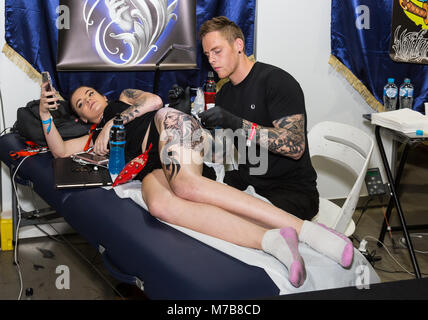 A young woman getting tattoos done at the Australian Tattoo Expo, International Convention Centre, Darling Harbour, Sydney. This event represents the culture of body ink and also promotes the skills of world-renowned artists in Australia and around the world. Credit: Paul Lovelace/Alamy Live News Stock Photo