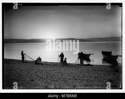 Choice set of thirteen slides, illustrating the Sea of Galilee and its fishermen still 'toiling with their nets.' Mending nets at dawn LOC matpc.05685 Stock Photo