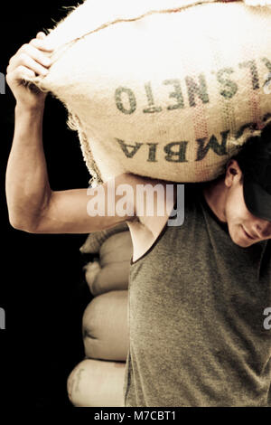 Man carrying a sack of coffee beans Stock Photo