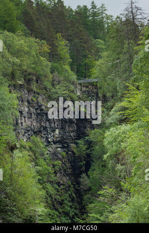 Braemore, Scotland - June 8, 2012: Corrieshalloch Gorge, a deep cut in landscape with forested vertical slopes. Suspension bridge over chasm. Focus on Stock Photo