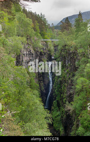 Braemore, Scotland - June 8, 2012: Corrieshalloch Gorge, a deep cut in landscape with forested vertical slopes. Suspension bridge over chasm. Waterfal Stock Photo