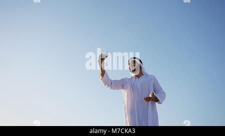 Portrait of Arabian sheikh man with gadget that communicates in  Stock Photo