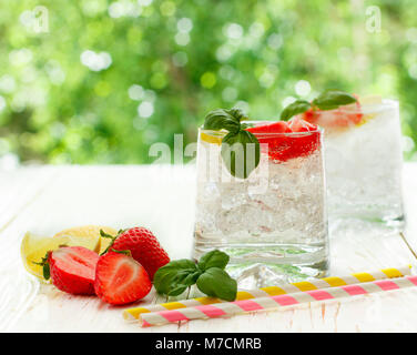 Summer a refreshing lemonade. Drink with lemon, strawberries, mint, Basil and ice. Detox. Mineral water. Selective focus Stock Photo