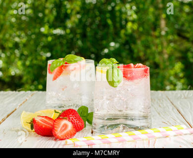Summer a refreshing lemonade. Drink with lemon, strawberries, mint, Basil and ice. Detox. Mineral water. Selective focus Stock Photo