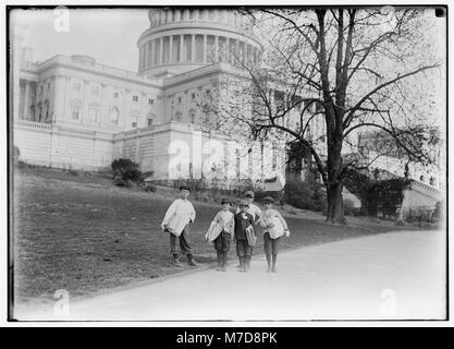 In comparison with governmental affairs newsies are small matters. This photo taken in the shadow of the National Capitol where the laws are made. This group of young newsboys sells on the LOC cph.3c22959 Stock Photo