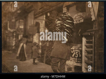 Man loaded down with heavy bundle of vests that he had been carrying for many blocks, stopping to rest, occasionally, when he would drop the bundle down onto whatever boxes or railings were LOC nclc.04154 Stock Photo