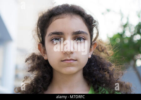 Serious Middle Eastern girl staring outdoors Stock Photo
