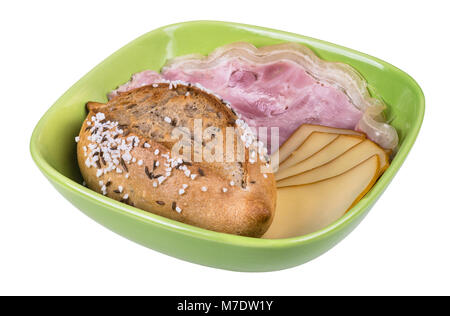 Salty bread roll, slices of ham hock and cheese. Crunchy whole grain bun, sliced pork meat and smoked edam in green bowl. Isolated on white background. Stock Photo