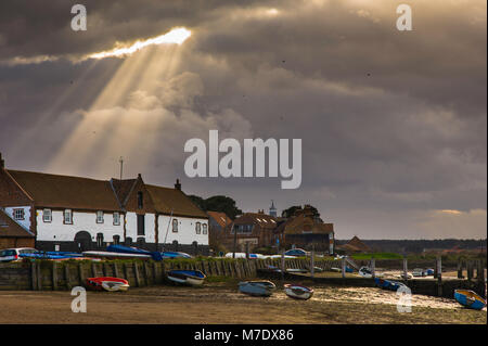 Crepuscular rays also known as God beams at Burnham Overy Staithe. Stock Photo