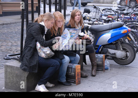 Three young tourists looking at the city map of Dublin in Temple Bar, Dublin in Southern Ireland Stock Photo