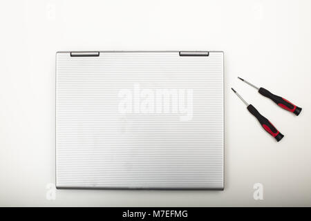 Modern laptop computer with precision tools lying on a white background viewed from above in a maintenance and DIY repair concept Stock Photo