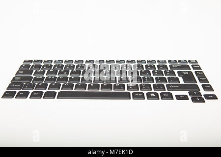 Low angle view of a qwerty alphanumeric computer keyboard with black keys on silver gradient to white with copy space above Stock Photo