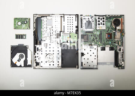 Studio shot high-angle view close-up of precision screwdriver and disassembled laptop computer in a repairs or maintenance concept over white backgrou Stock Photo