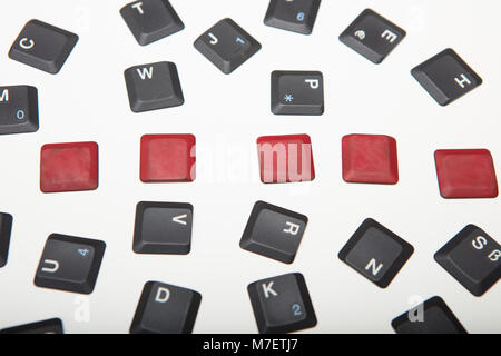 Overhead view of a composed  alphanumeric computer keyboard with five blank red keys on silver gradient to white with copy space above Stock Photo