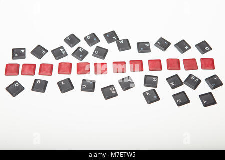 Overhead view of a composed  alphanumeric computer keyboard with twelve blank red keys on silver gradient to white with copy space above Stock Photo
