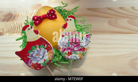 close of view of hens and egg with red bow on wooden background Stock Photo