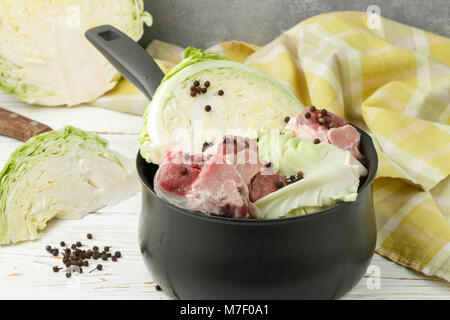 Cooking the traditional Norwegian dish of braised cabbage with lamb (Forikol). The ingredients on the table. Vegetables, meat , black pepper and spice Stock Photo