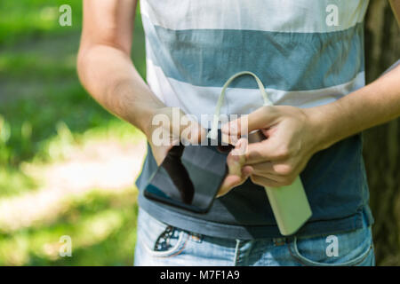Photo of man holding phone and powerbank Stock Photo