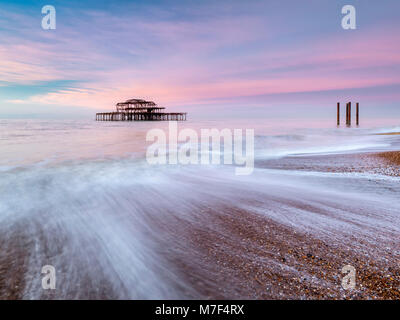 Pink sky over the old west pier at sunrise. Stock Photo