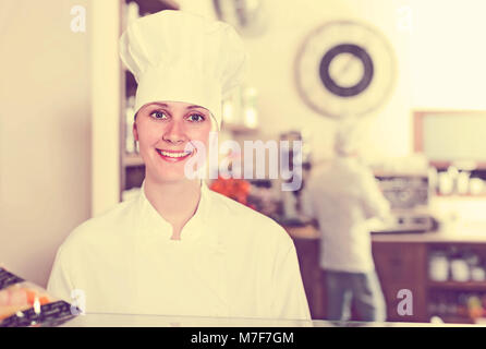 portrait of young attractive woman baker with tasty cakes and rolls in the bakery Stock Photo