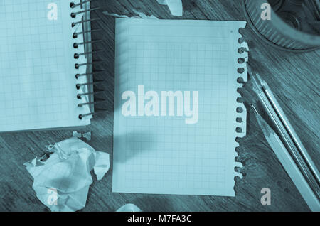 Crumpled empty pages and notebook lying on wooden surface Stock Photo