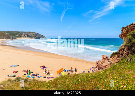 PRAIA DO AMADO BEACH, PORTUGAL - MAY 15, 2015: Surfers relaxing on sandy beach on sunny beautiful day. Water sports are popular activity in this regio Stock Photo