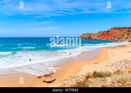 Surfers on Amado beach with big sea waves, Algarve, Portugal Stock Photo
