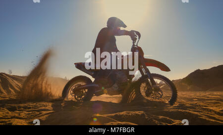 Professional Motocross FMX Motorcycle Rider Drives in Circles on the Off-Road Deserted Quarry. Stock Photo