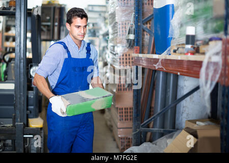 Seller male is checking bags with cement in the building store. Stock Photo
