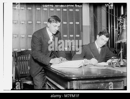 Two new citizens sign naturalizaton papers in judge's chambers, from the Bain Coll. - Bain Collection LCCN2014684477 Stock Photo