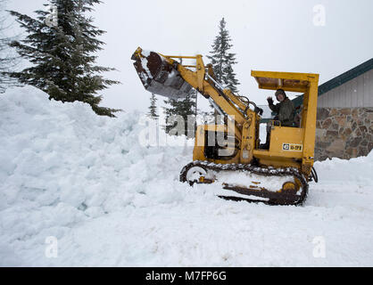 Clearing snow from around the house with a Cat 931 loader. in Sanders County, Montana Stock Photo