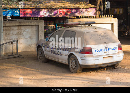 Tourist police car, dirty with wash me on back window, parked outside shop at Bagan, Myanmar (Burma), Asia in February