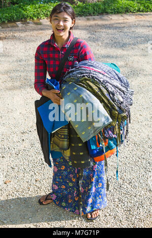 Young Burmese woman selling longyis to tourists at Bagan, Myanmar (Burma), Asia in February Stock Photo