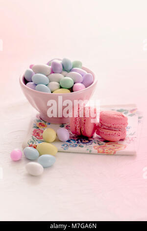 Jordan almonds and macaroons on a plain background Stock Photo