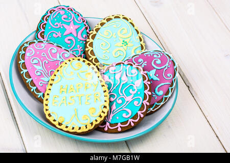 Easter homemade baked gingerbread cookies in the form of eggs with different pattern of icing on plate Stock Photo