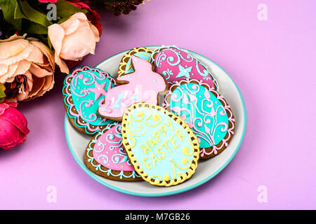 Easter homemade baked gingerbread cookies in the form of eggs with different pattern of icing on plate Stock Photo