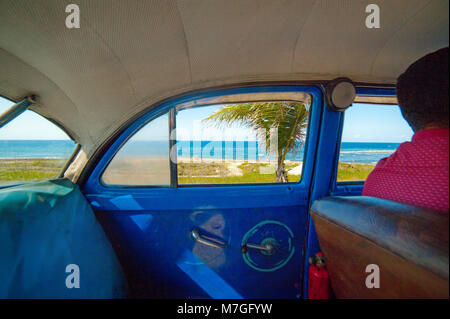 Inside of a blue classic taxi in Havana, Cuba, with a view of the Caribbean Sea out the window Stock Photo