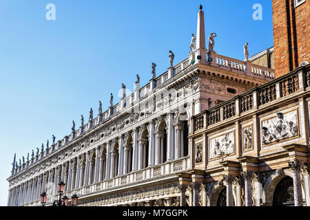 Daylight view to Marciana Library renaissance style facade and campanile entrance from Saint Mark's square. Bright blue clear sky. Negative copy space