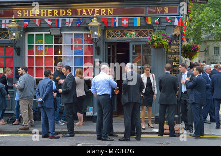 Formally dressed employees enjoying after work drinks at the Shepherds Tavern, London UK Stock Photo