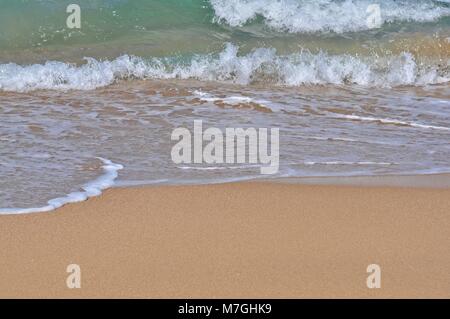 Small waves breaking at the shoreline. Stock Photo