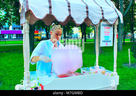 The girl sells the sweet cotton wool in the city park Stock Photo