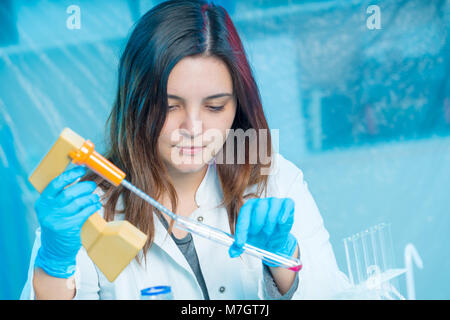 young woman technician uses a pipette in a chemical lab Stock Photo