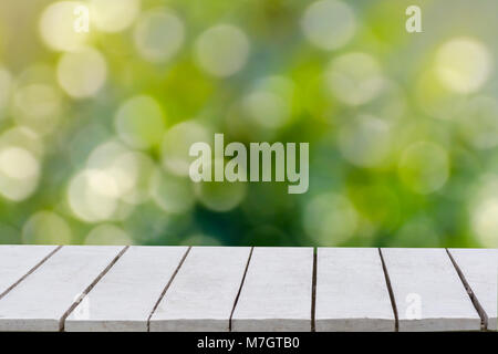 natural green background with selective focus. The green background has a bokeh leaf and grass on a white wooden floor. Empty table empty space wooden Stock Photo