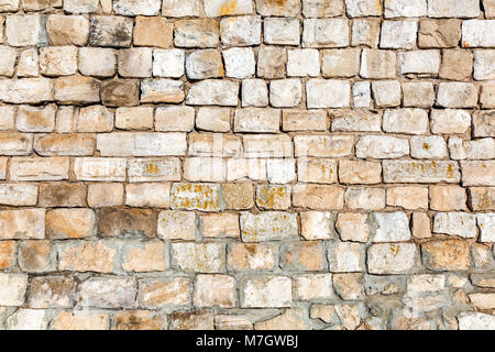 Weathered grey stone wall as background texture Stock Photo