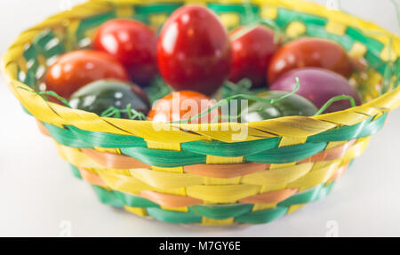 Easter eggs in colorful wooden basket, decorative isolated on white Stock Photo